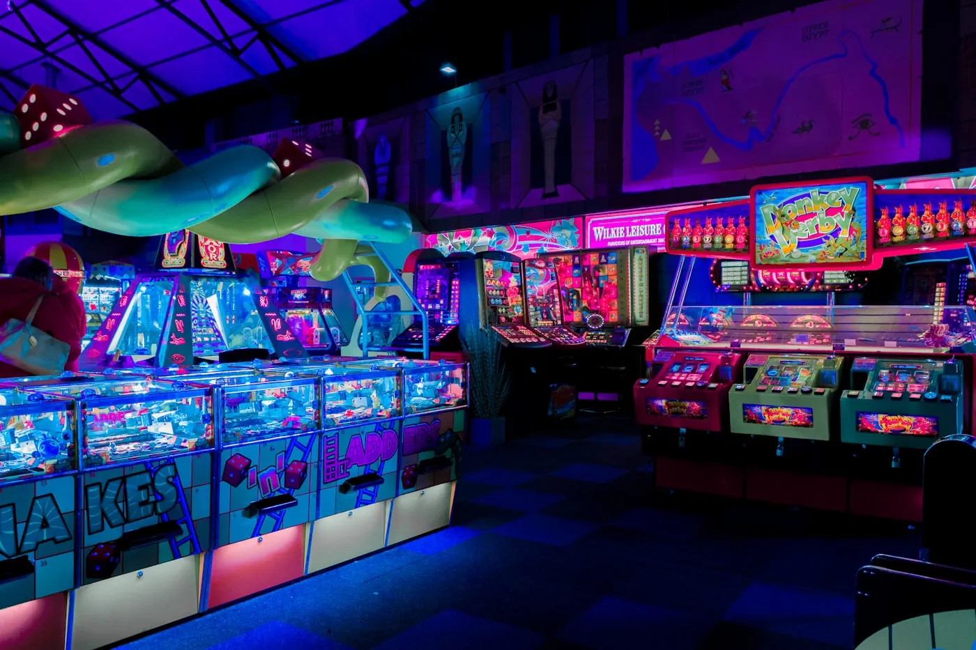 A vibrant neon-lit arcade full of glowing cabinets and screens