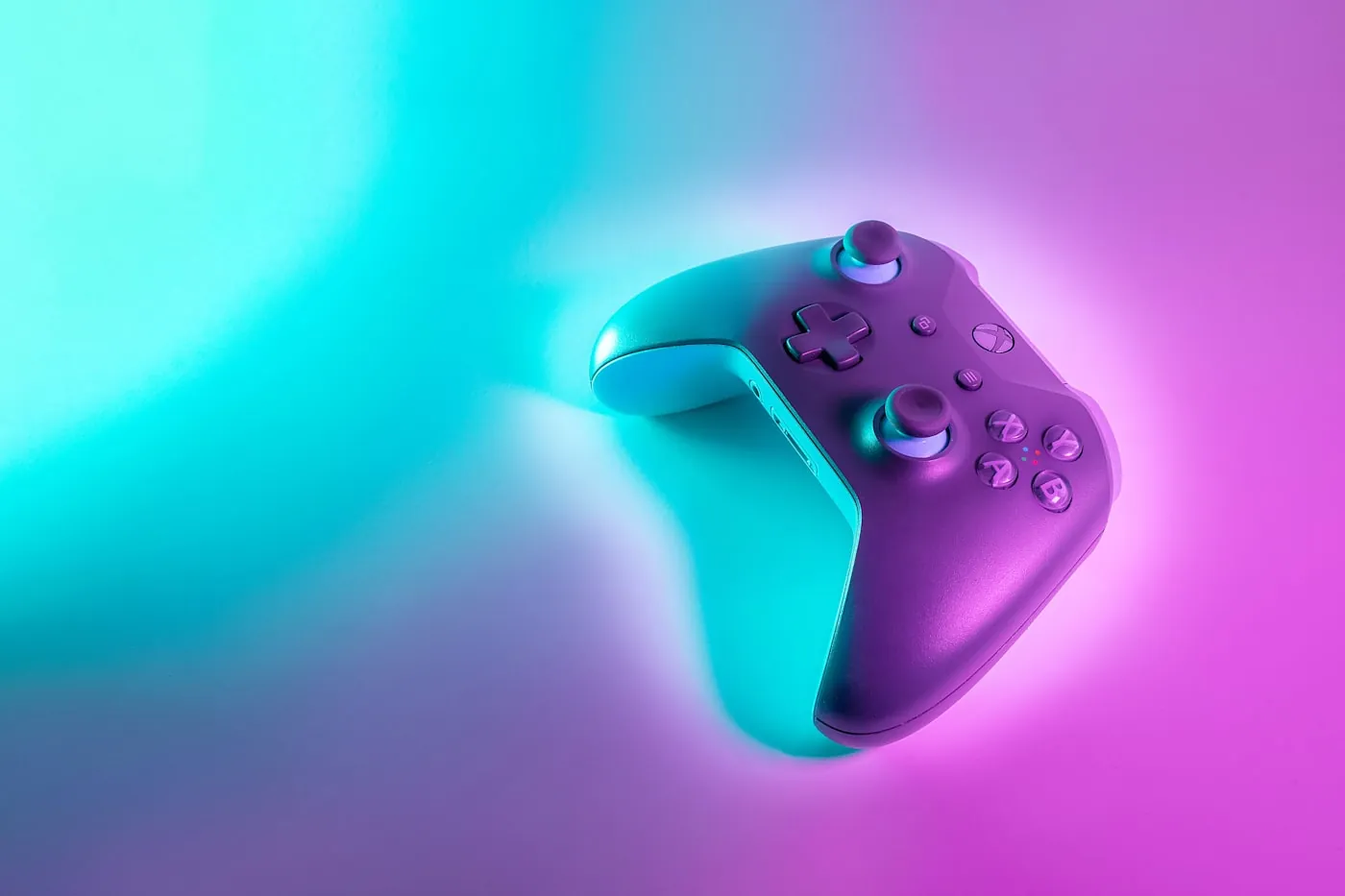 A game controller lit in pink and teal neon — the NC Eclectic palette in real life
